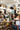 A busy retail shop interior filled with shelves of cowboy hats and straw hats, with customers browsing and holding hats-FleaStyle