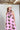 Woman wearing a Monstera-Leaf-Print-Halter-Maxi-Dress-Pink and a Brooks Straw Cowbowy Hat White-FleaStyle