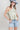 Woman wearing a floral top, High-Rise-Raw-Hem-Midi-Denim-Short and a wide-brimmed dusty blue cowboy hat-FleaStyle