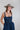 Woman wearing a Western-Ivory-Stone-Bolo-Tie, a Lace-Up-Corset-Midi-Dress-Dark-Denim and gray flat brim hat -Fleastyle 
