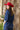 Woman in a Chambray Studded Button Down - Dark Denim and red cowboy hat sitting on a chair in a room with curtains and plants-Fleastyle