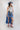 Woman wearing an Ivory-Squash-Blossom-Necklace, blue cowboy hat, striped tank top, blue high-low skirt, and pink cowboy boots-Fleastyle