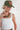 A woman wearing an olive green trucker hat with an embroidered butterfly on the front and a vintage necklace with deep burgundy strands, antiqued gold- and silver-tone metal accents creates a bold, architectural collar-length look-Vintage_Burgundy_Mixed_Metal_Collar_Necklace-FleaStyle