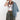 A woman wearing olive green camouflage wide-leg pants, a light blue denim jacket draped over her shoulder, a green baseball cap with a butterfly patch, and layered beaded necklaces-Vintage Wooden Beaded Necklace - Pink/Purple-FleaStyle