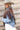 Woman wearing a cowboy hat, denim shacket, and studed fringed shrug with cowboy boots-FleaStyle
