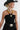 A woman wearing a black straw cowboy hat and black strapless dress with avintage beaded necklace featuring mustard marbled beads, large black cylindrical beads, pops of red and turquoise accents, antiqued silver-tone spacer beads, and an oversized cream mosaic tile pendant -Vintage_Mixed_Bead_Mosaic_Pendant_Necklace-FleaStyle