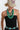 A woman wearing a beige trucker-style cap with a colorful butterfly patch, a black strapless dress,avintage turquoise-hued geometric beads with dark marbled detailing and small metal accents-Vintage_Turquoise_Geometric_Statement_Necklace-FleaStyle