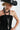 A woman wearing a black straw cowboy hat  with a long silhouetted necklace with matte black beads, sparkling crystal details an eclectic drop of sculptural beads, a silver-tone heart charm, and a silver-tone star charm--Vintage_Long_Black_Beaded_Charm_Necklace-FleaStyles 