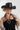 A woman wearing a black straw hat, a black ribbed strapless dress, a silver sage bandana scarf and a silver heart-shaped pendant necklace with a strand of black and clear faceted beads-Vintage Black Beaded Heart Pendant Necklace- FleaStyle