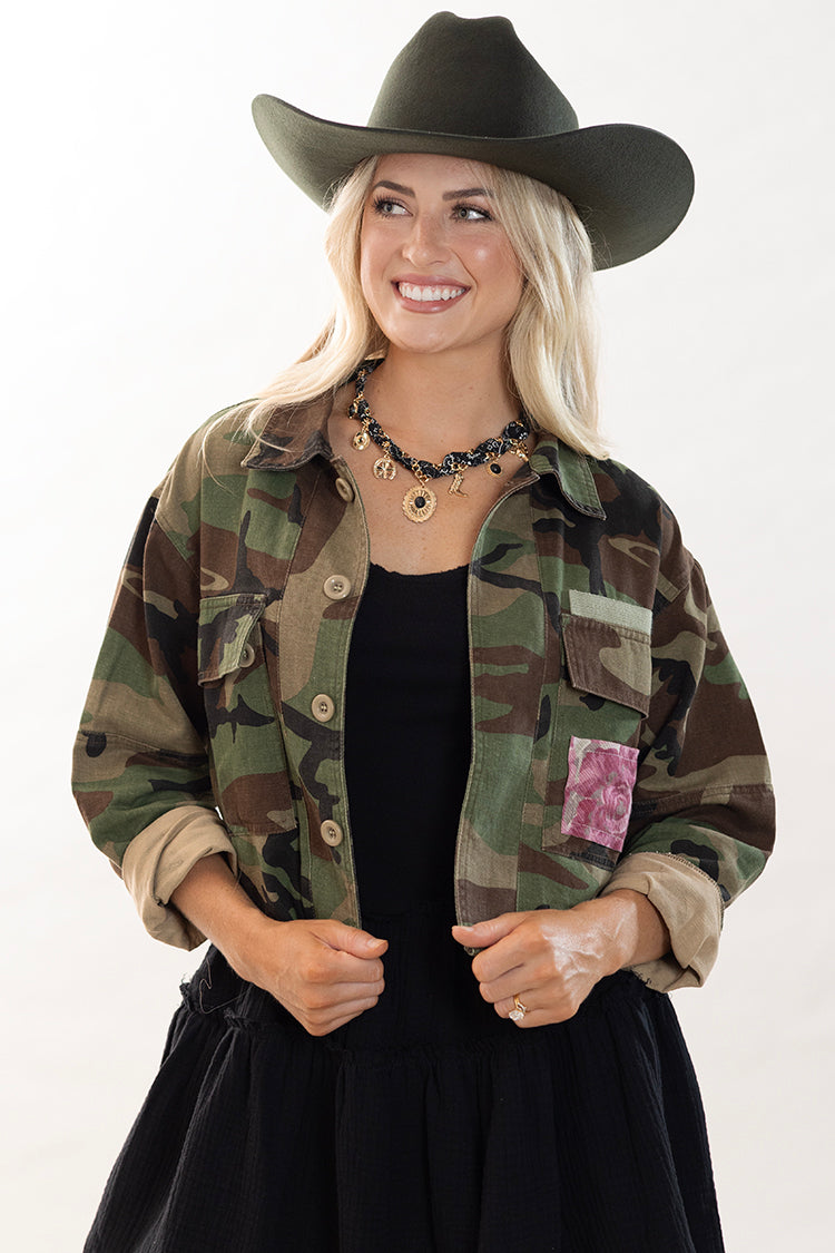Women wearing a camouflage crop jacket with floral patch and a black cowboy hat-Flea Style