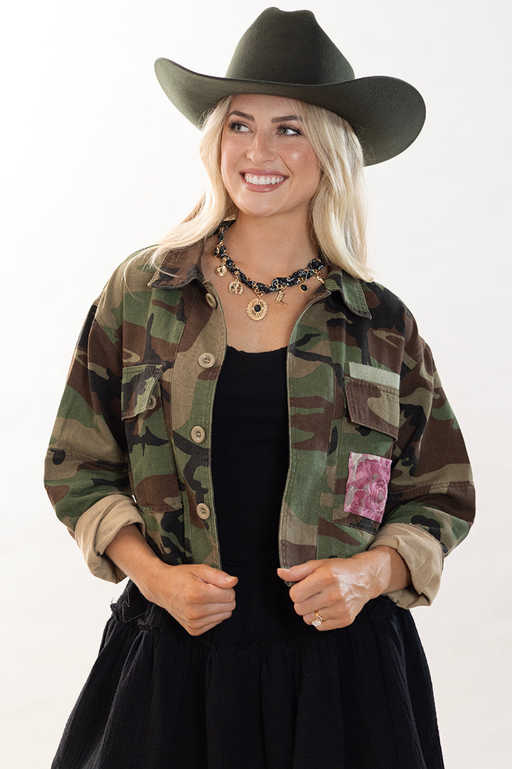 Women wearing a camouflage crop jacket with floral patch and a black cowboy hat-Flea Style