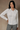Front view of the fitted white button-down shirt on a model, showing the pointed collar and long sleeves.