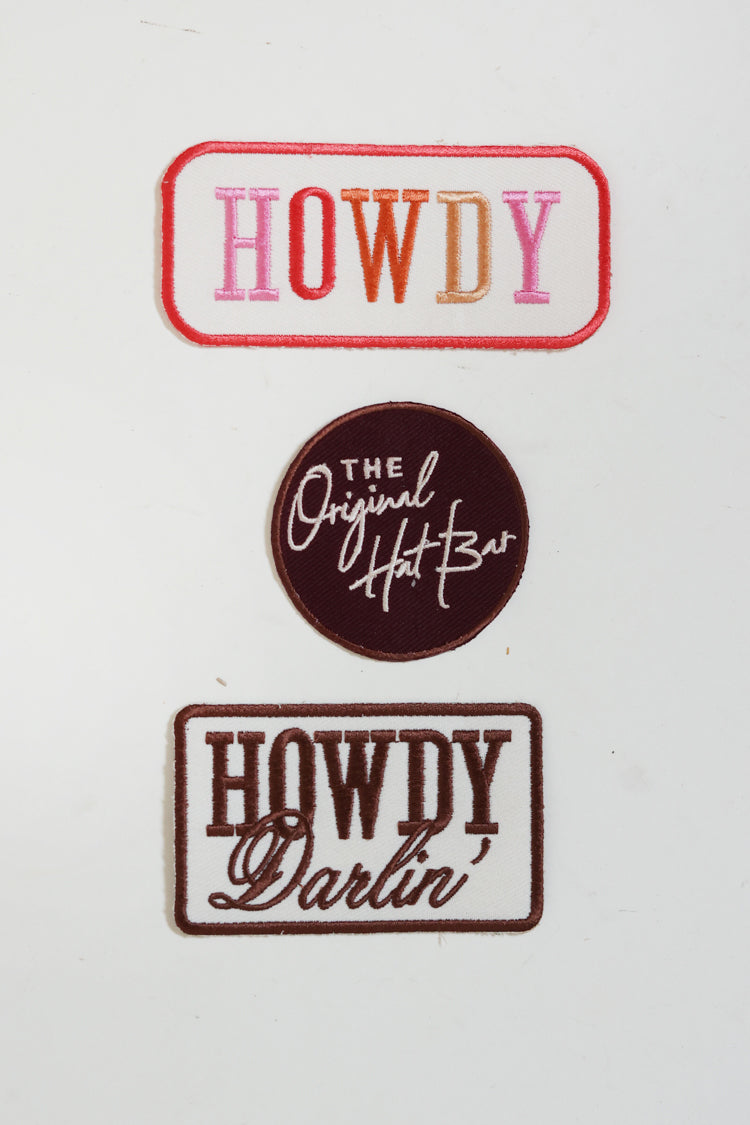Embroidered patch with  shades of pink letters 'HOWDY' text-Flea Style. 