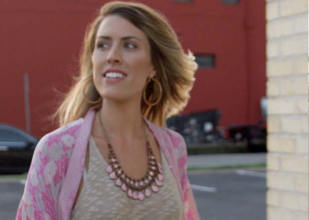 Woman walking down the street with a pink necklace 