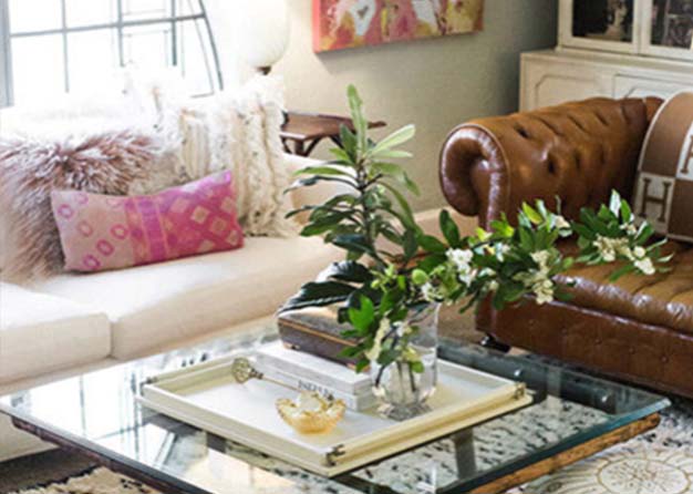 Sitting room decorated with couches, a rug, plants, and artwork