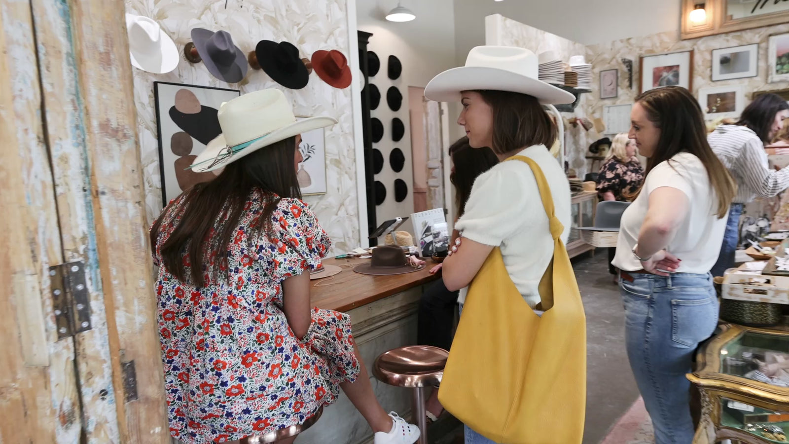 Women shopping and customizing hats at the Original Hat Bar with friends and stylists, showcasing the custom hat design experience and linking to book a reservation